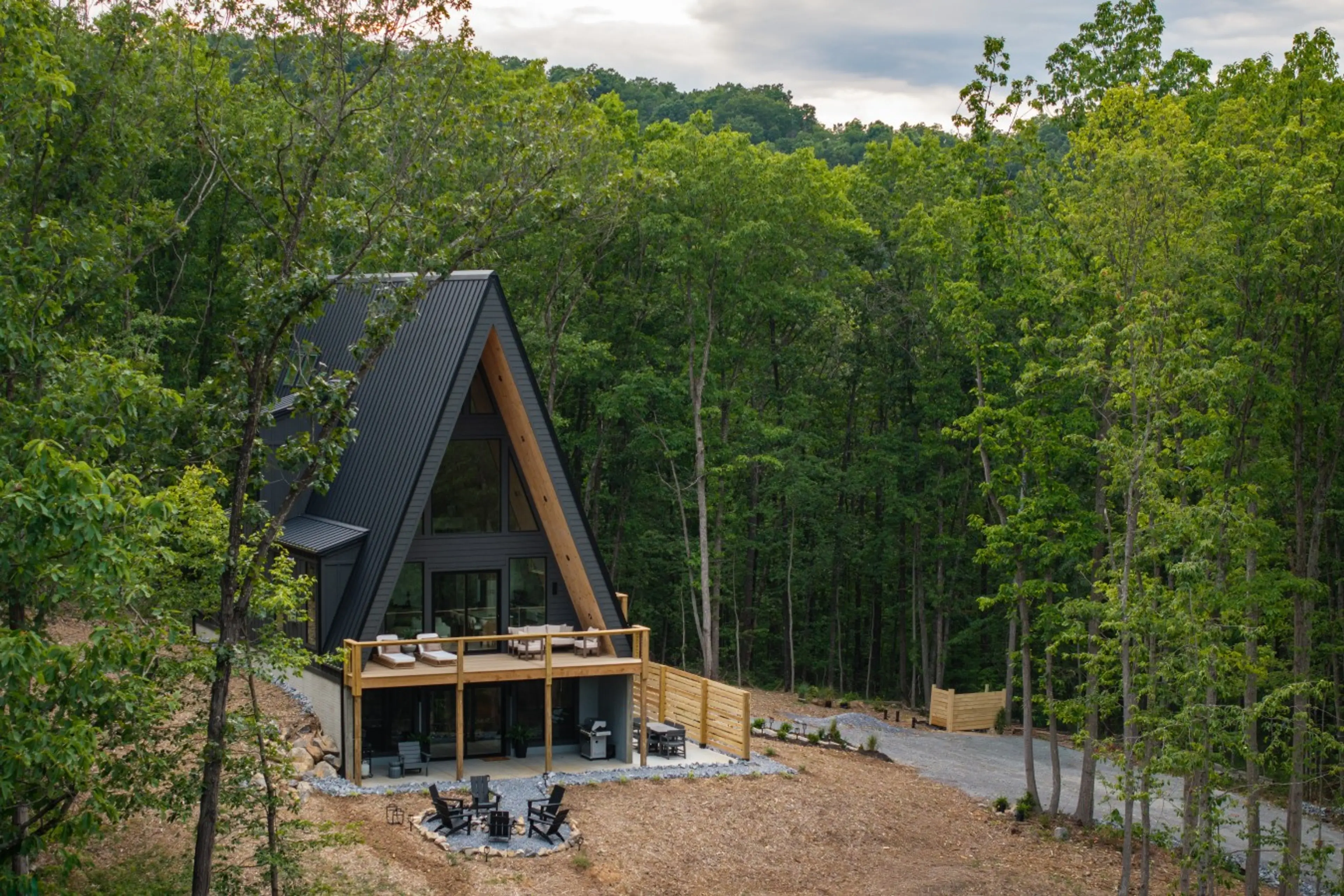 Solhaus Shenandoah cabin nestled in a forest clearing, aerial daytime view