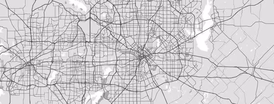 Grayscale map showing an urban area with a dense network of streets and highways, including a grid pattern in the center and surrounding irregular road layouts.