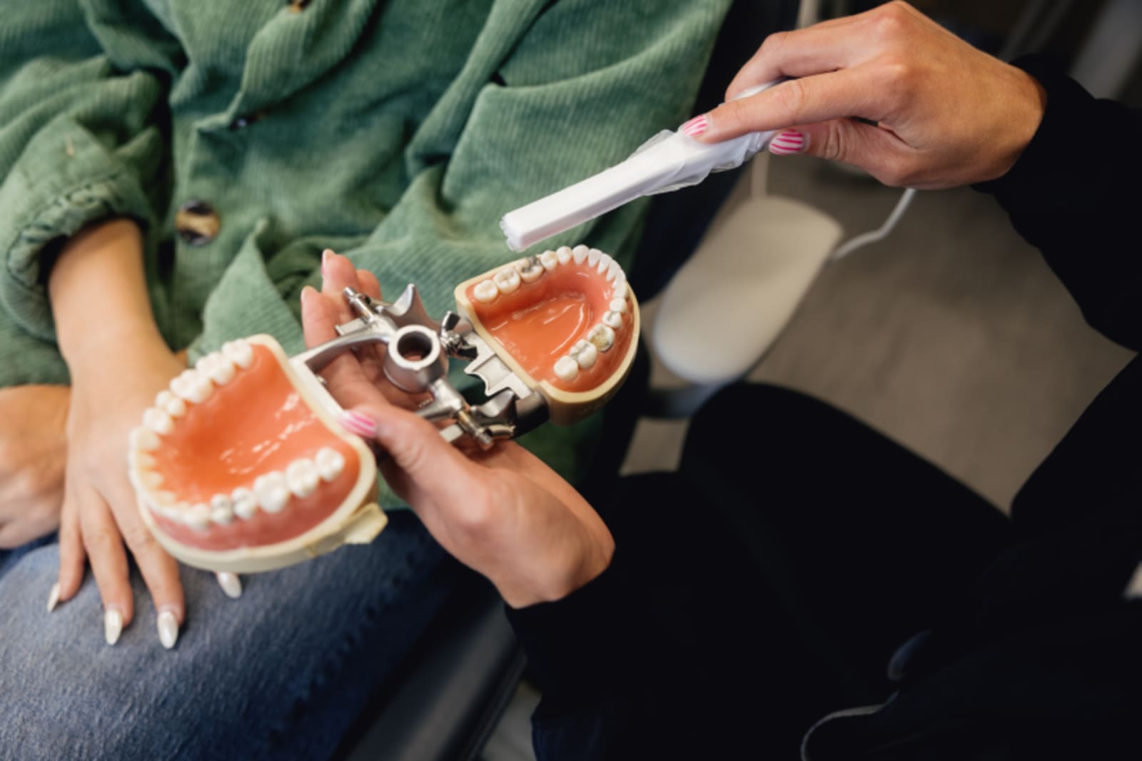 Dentist showing patient model teeth and demonstrating crown fitting options