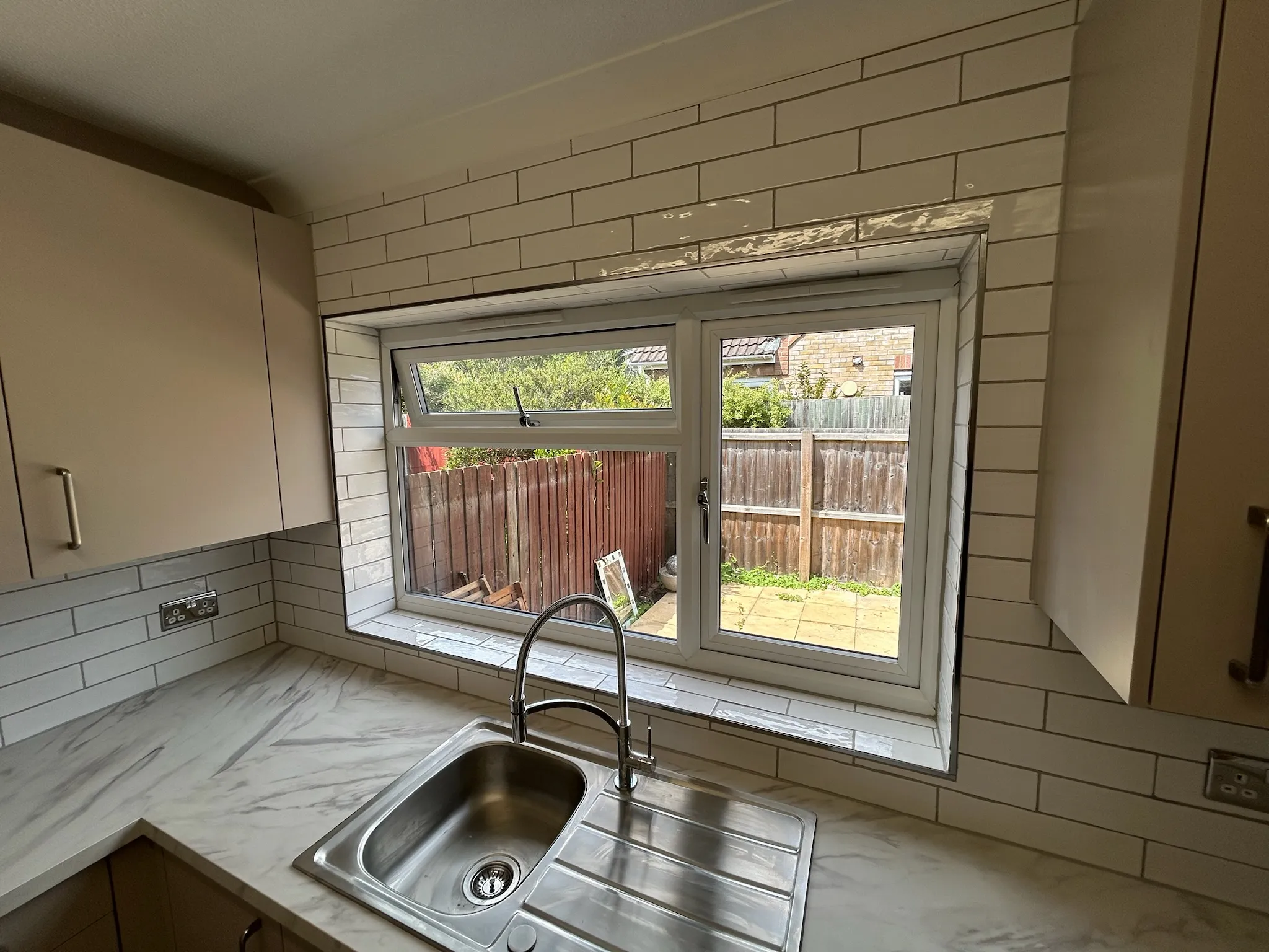 Newly installed kitchen with white tiles