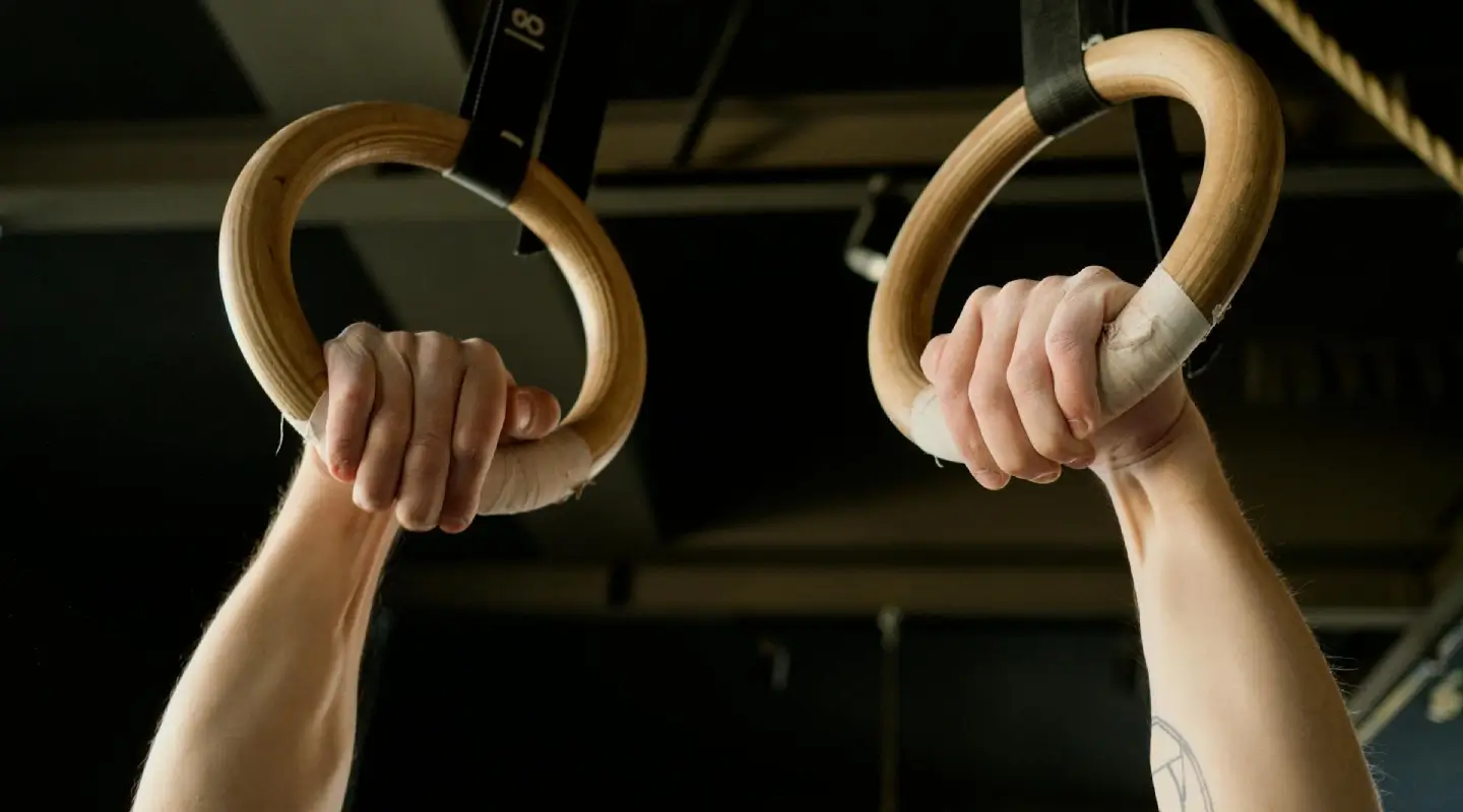 Athlete gripping gymnastic rings during functional fitness training at Lumen Athletics in Cheyenne, WY.