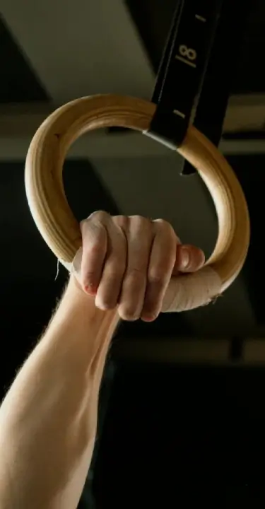 Athlete gripping gymnastic rings during functional fitness training at Lumen Athletics in Cheyenne, WY.