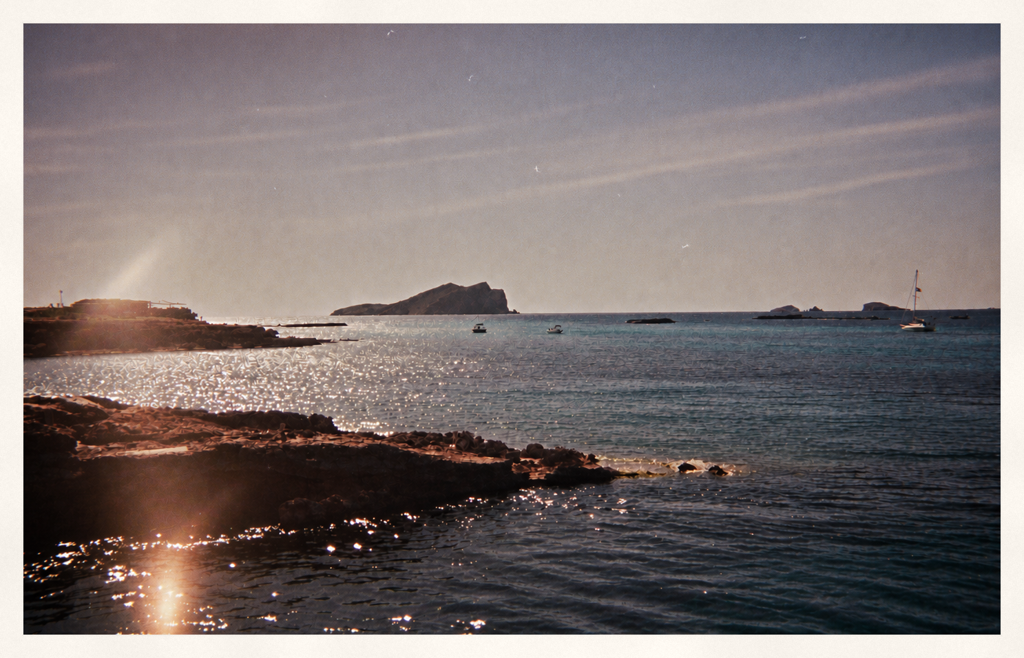 Sunlit sea and rocky coastline at golden hour