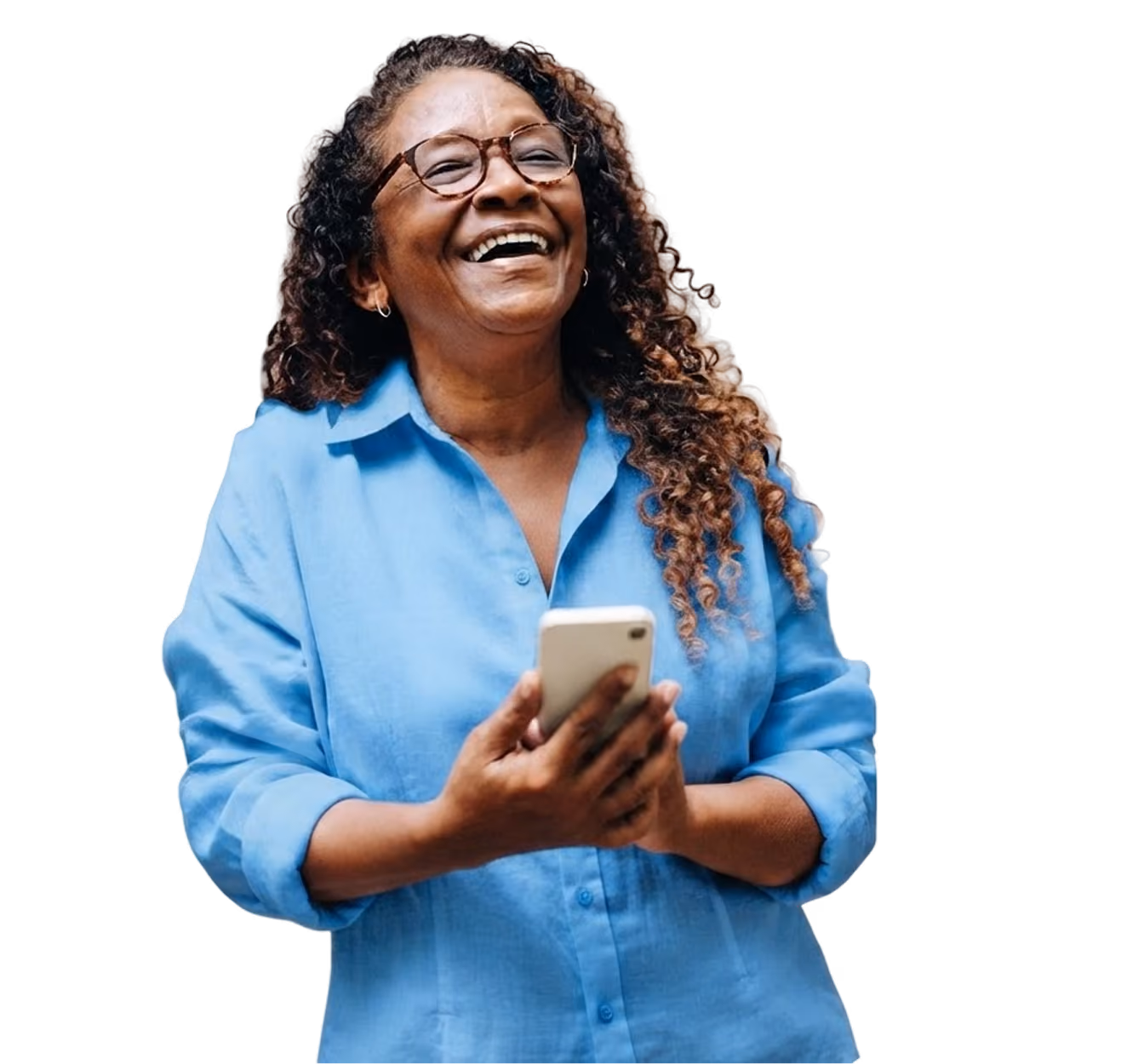 Mujer sonriente con cabello rizado y gafas, usando una camisa azul y sosteniendo un teléfono móvil con ambas manos.