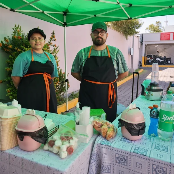 Equipo de Kash atendiendo un puesto bajo una carpa verde