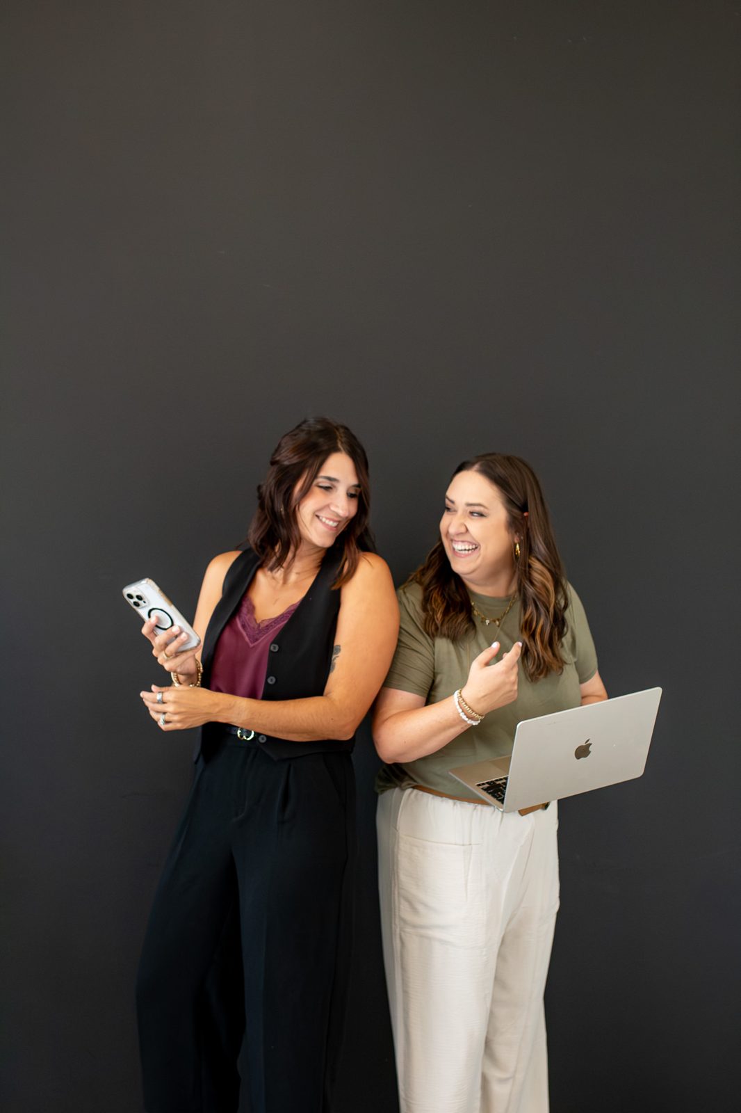 Brenna and Emily planning content on phone and laptop