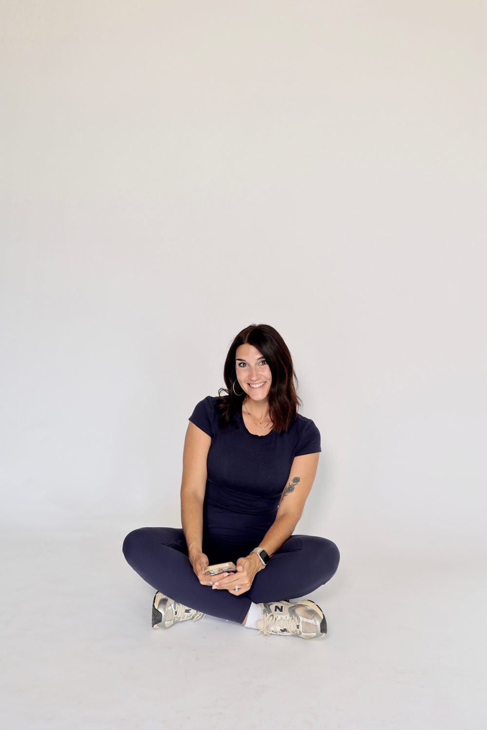 Relaxed and smiling, seated on the studio floor