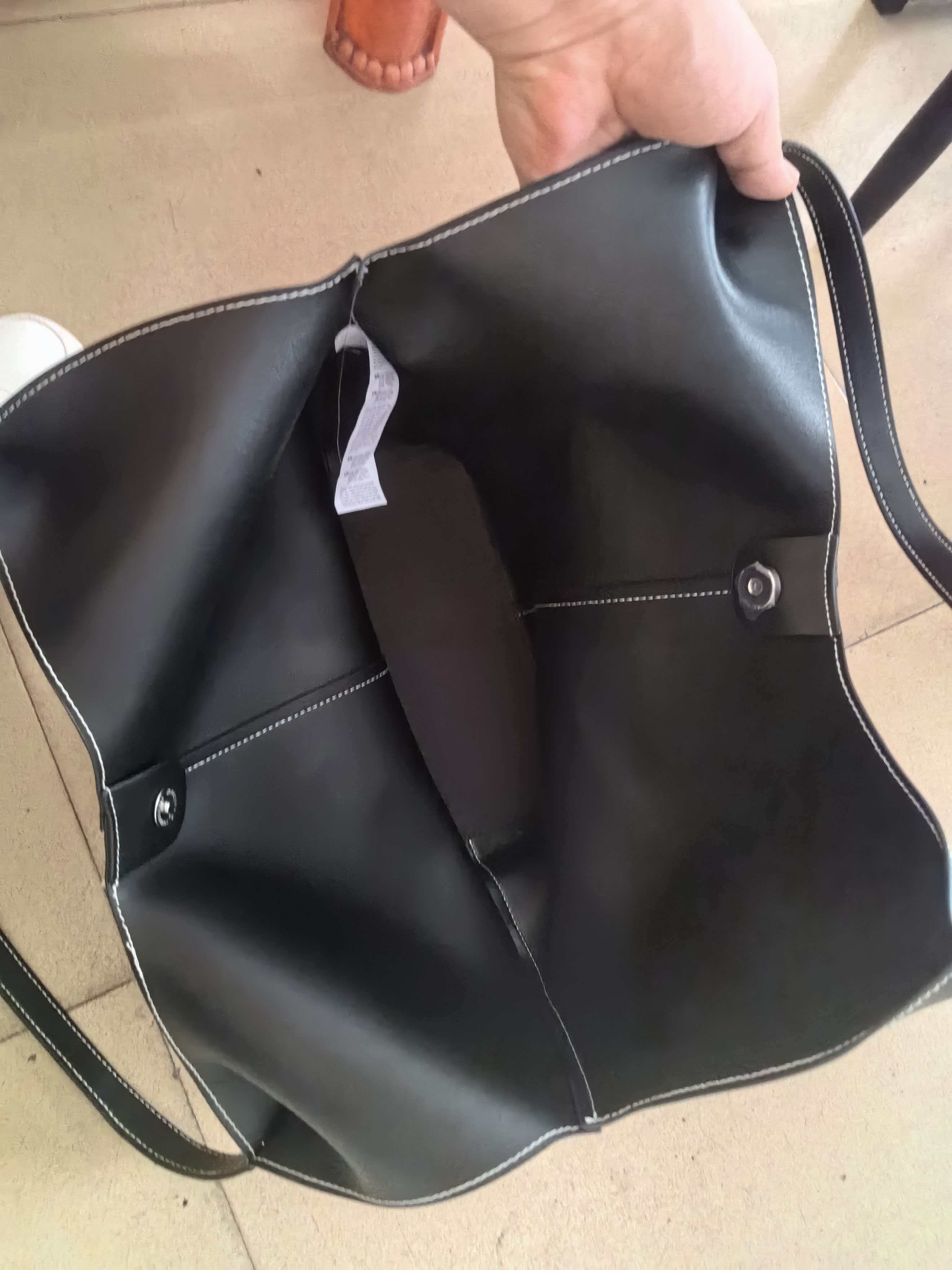 Front view of black leather hobo tote bag featuring spacious shoulder design