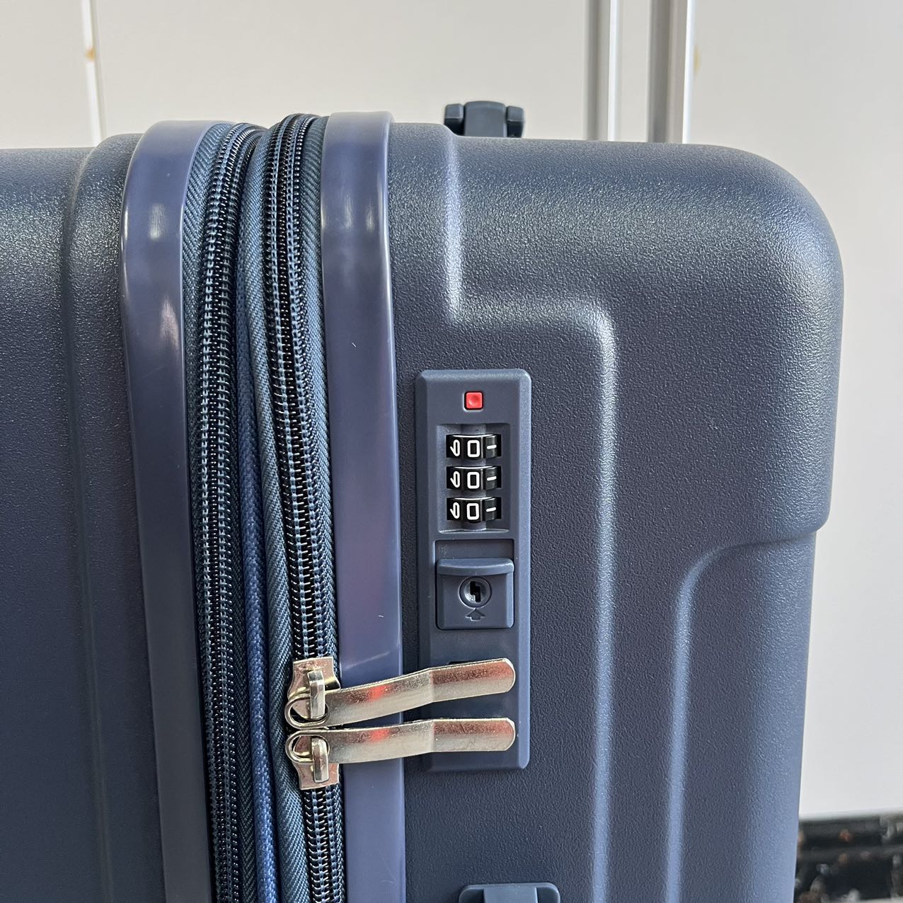 Close-up detail of blue luggage hard-shell texture and zipper