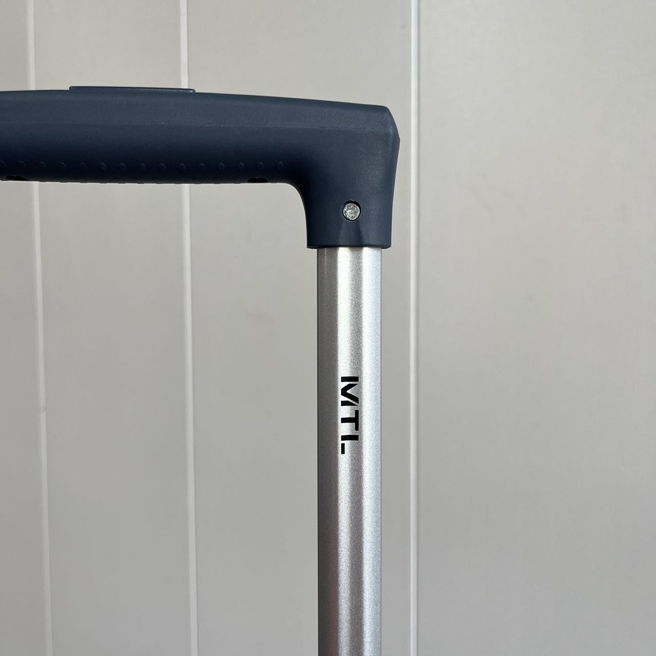 Close-up view of adjustable telescopic handle on blue suitcase