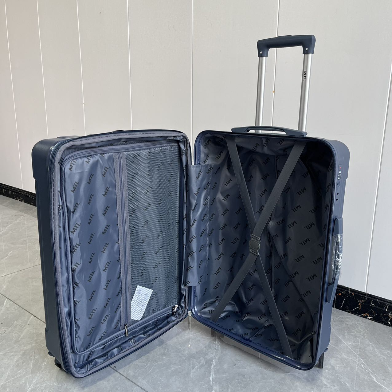 Open blue trolley suitcase showing interior zippered compartments