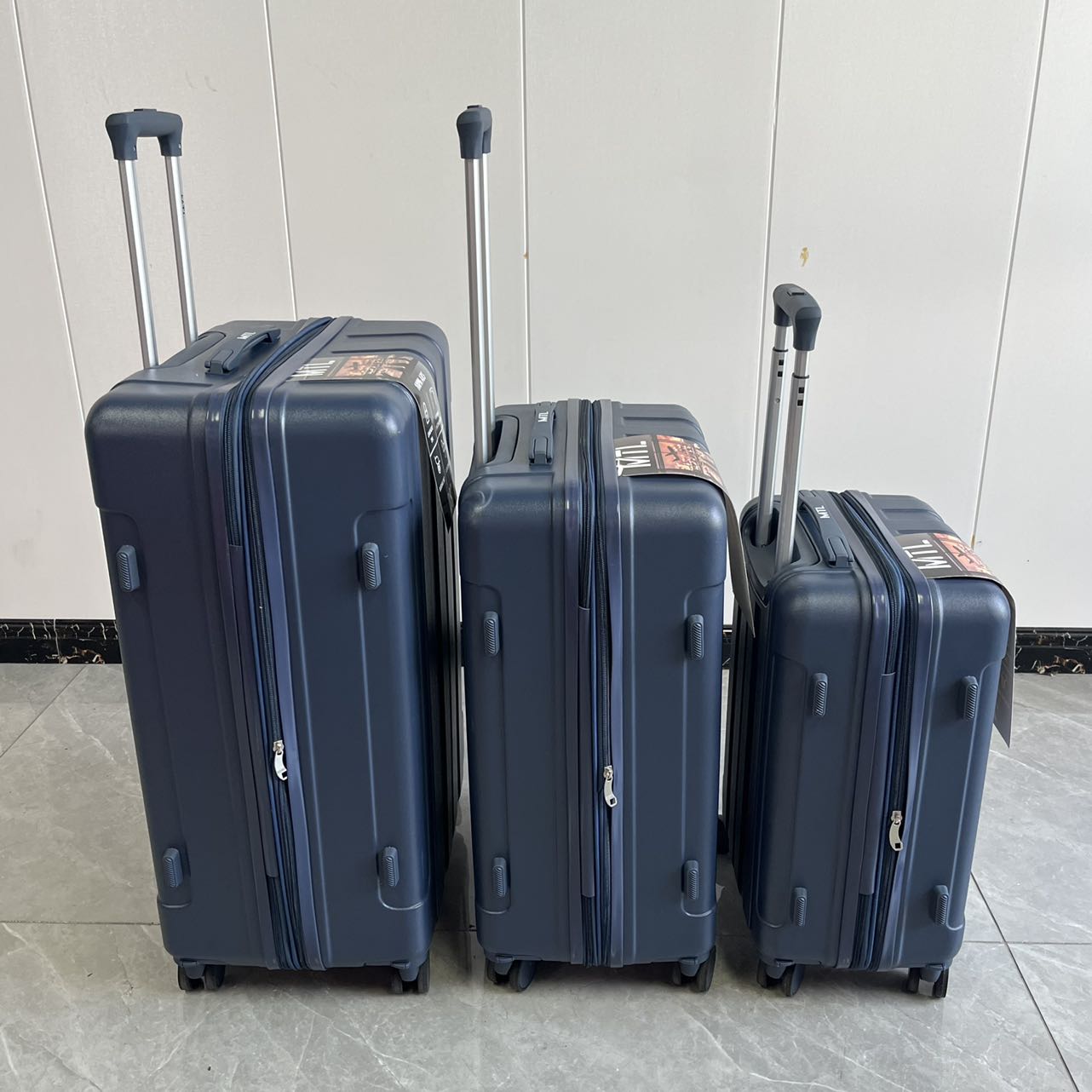 Back view of blue spinner luggage set with telescopic handles