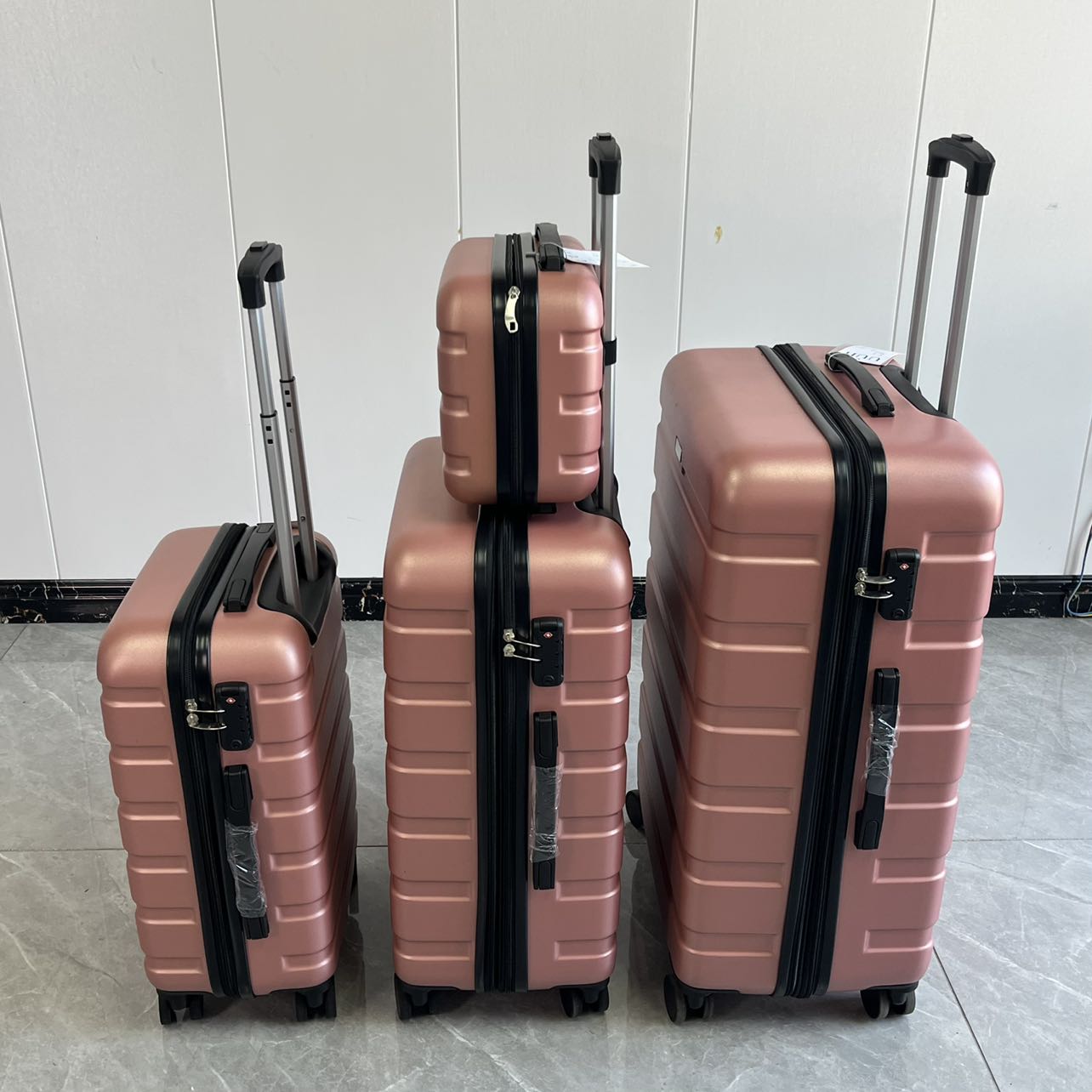 Front view of 4-piece rose gold luggage set with vanity case and spinner suitcases