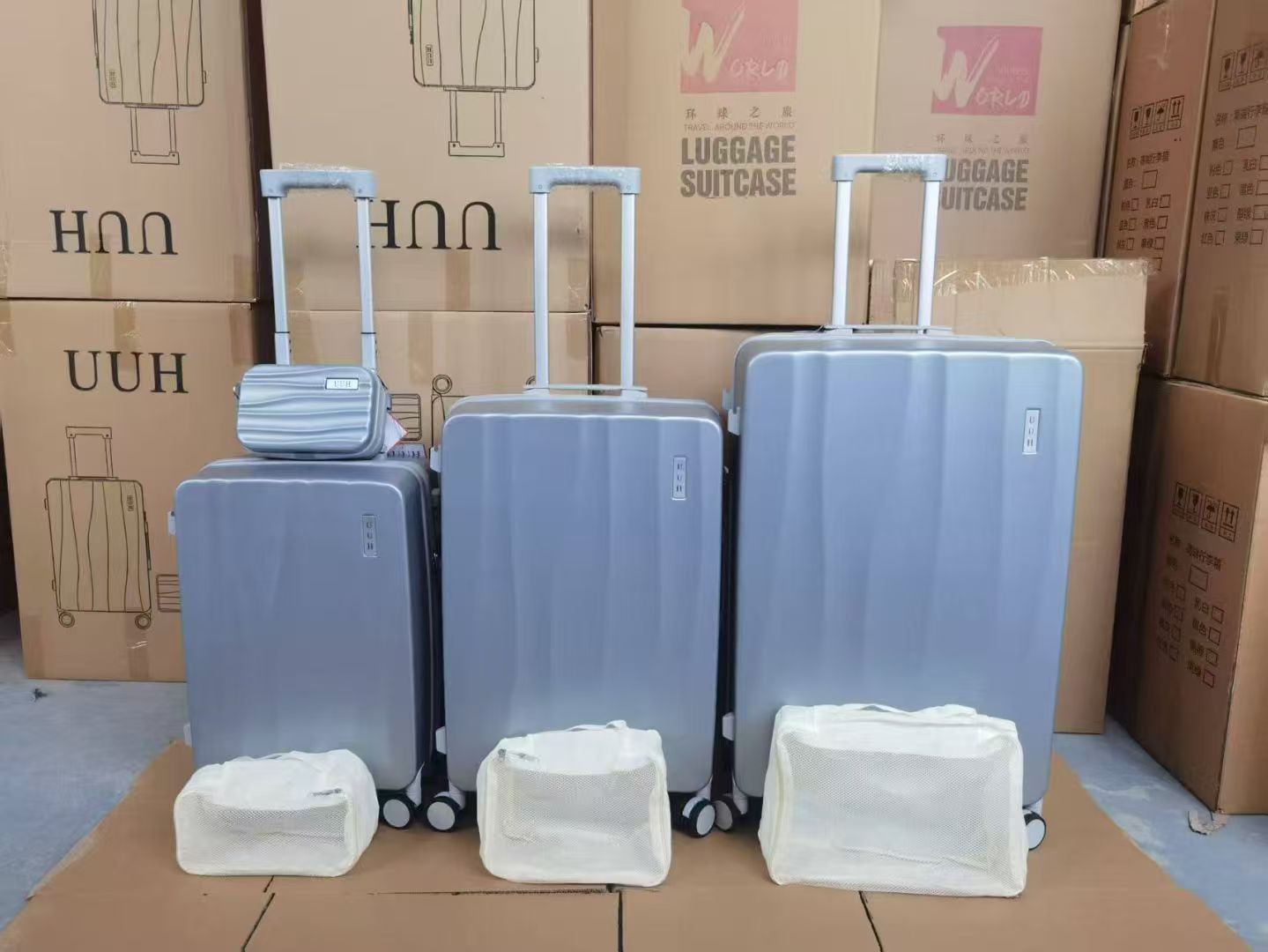 Set of blue hard-shell trolley luggage with vanity cases arranged in a warehouse