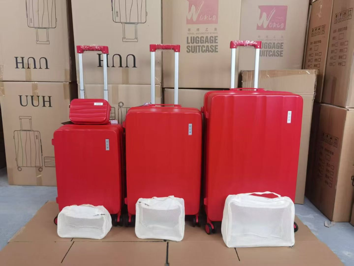 Set of bright red hard-shell trolley suitcases and matching vanity cases