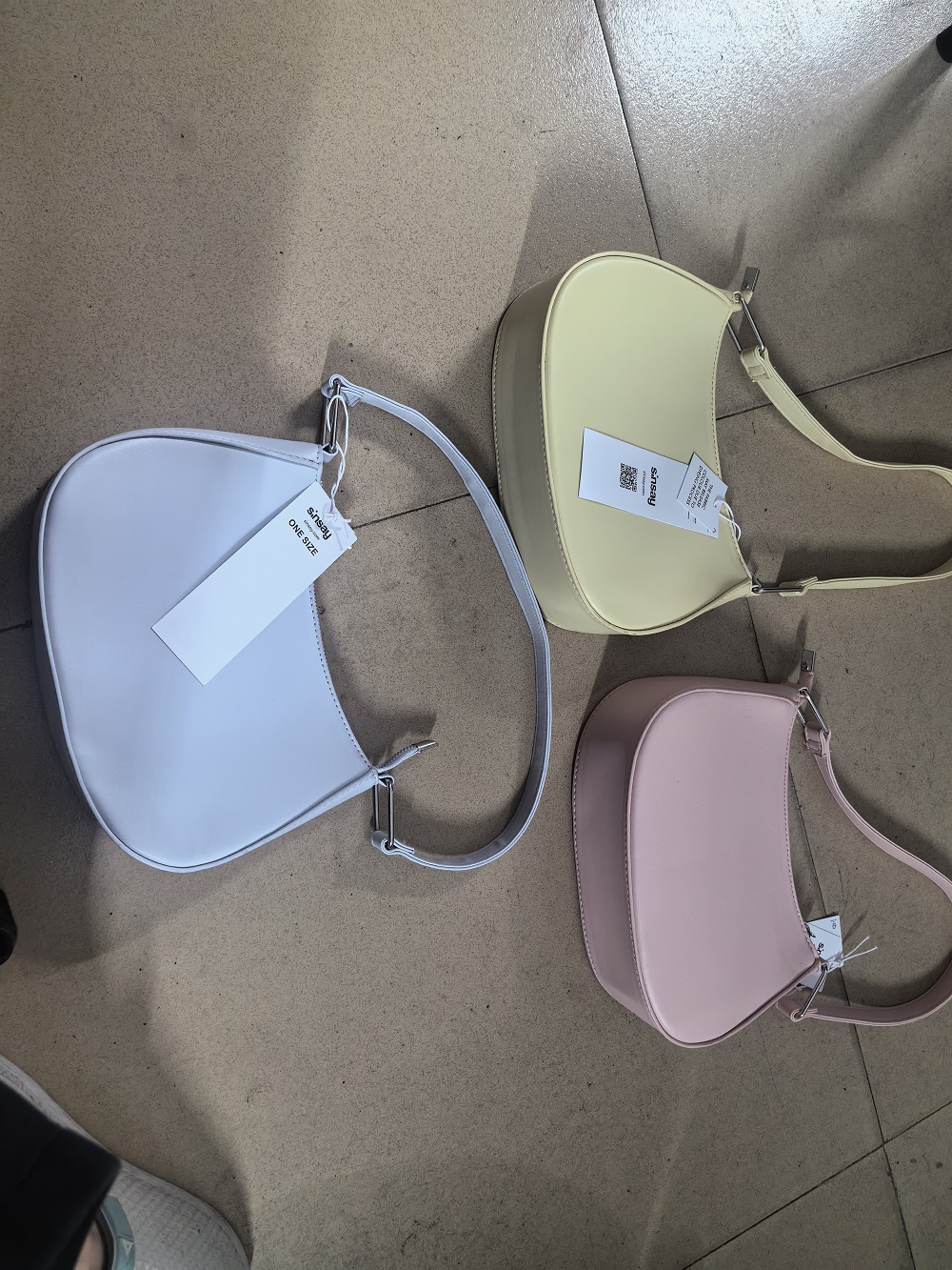 Cream leather ladies' hobo bag displayed with shoulder strap