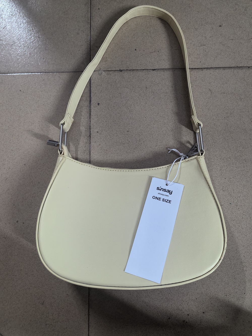 Front view of cream leather hobo bag placed on a flat surface