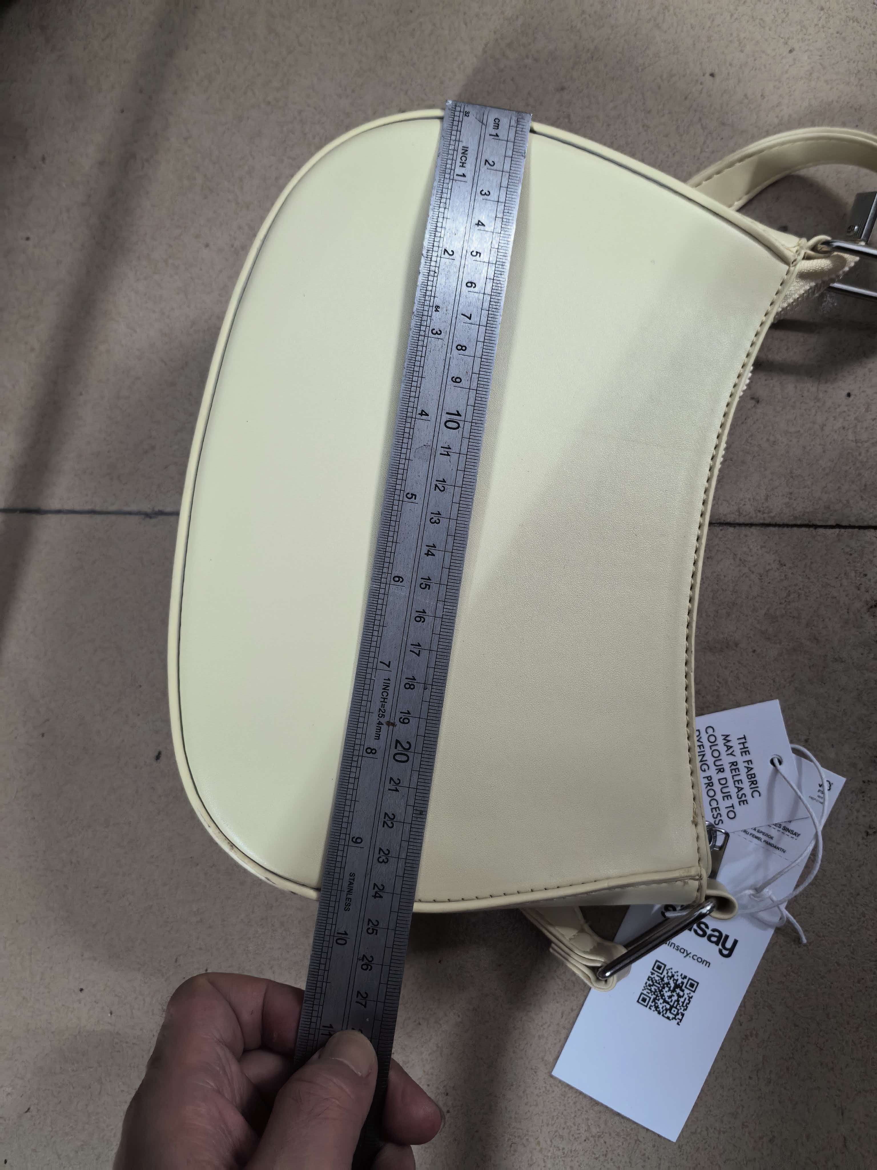 Side view of cream hobo bag showing shoulder strap connection and design