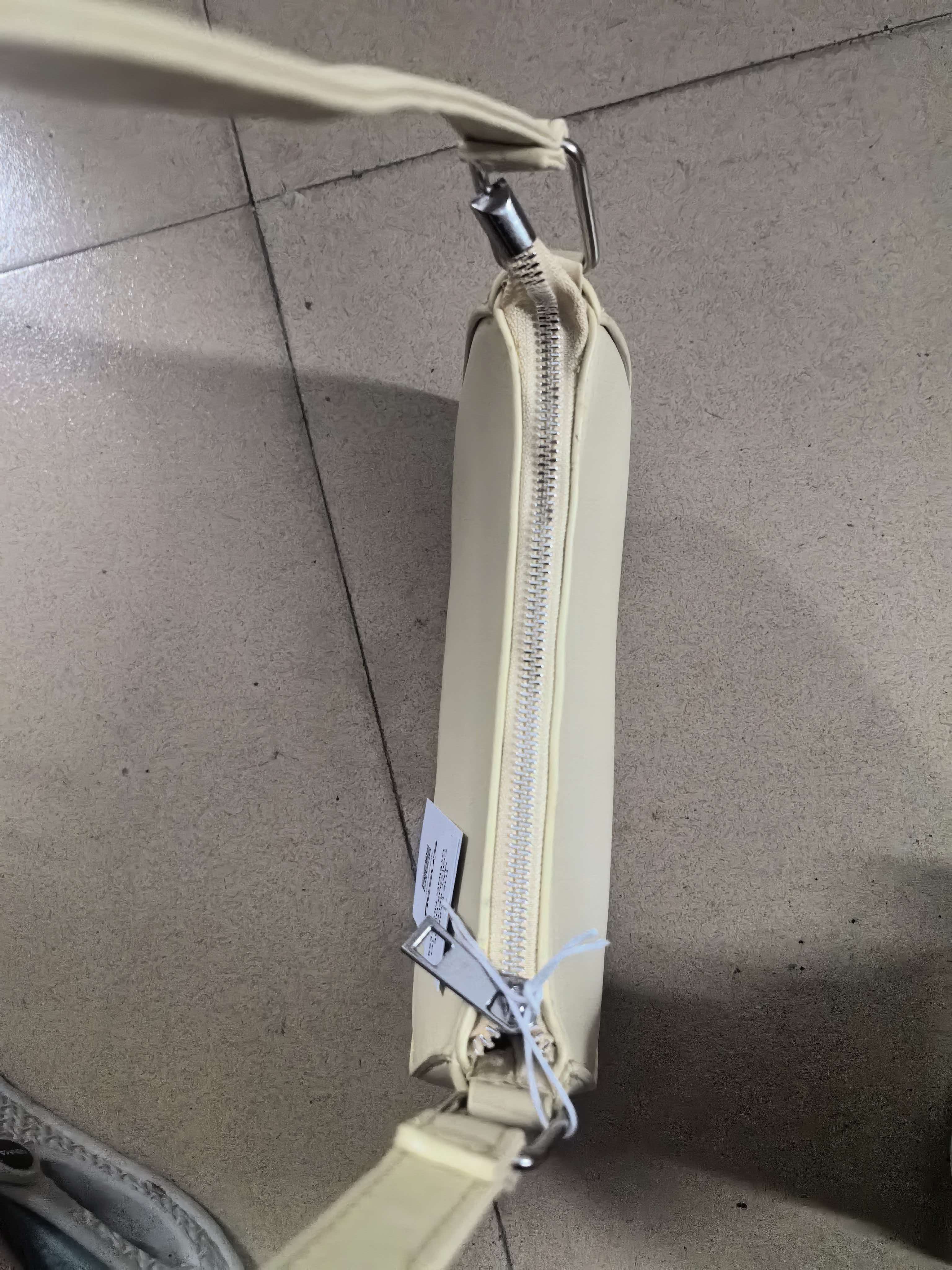 Full length view of cream hobo bag showing bag shape and strap length