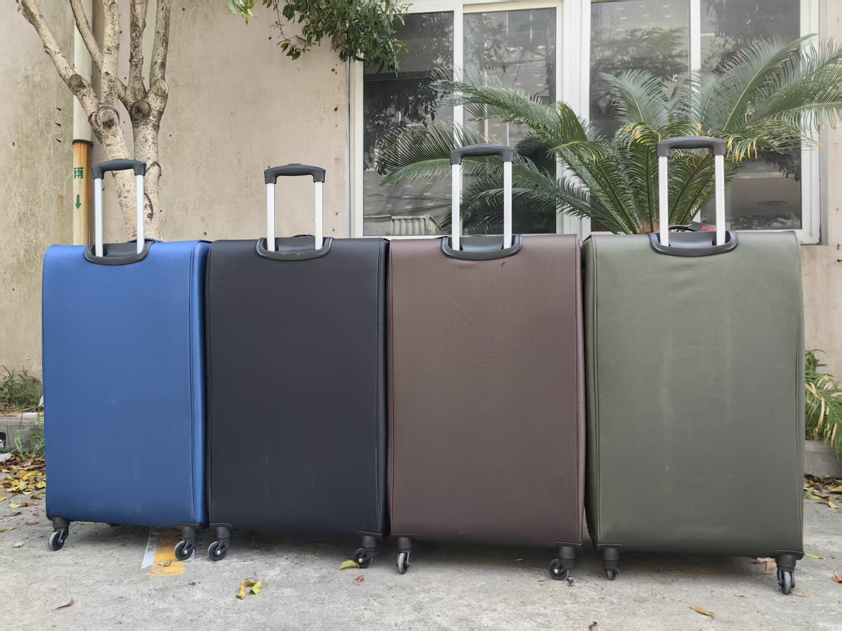 Front view of blue and gray trolley luggage set outdoors