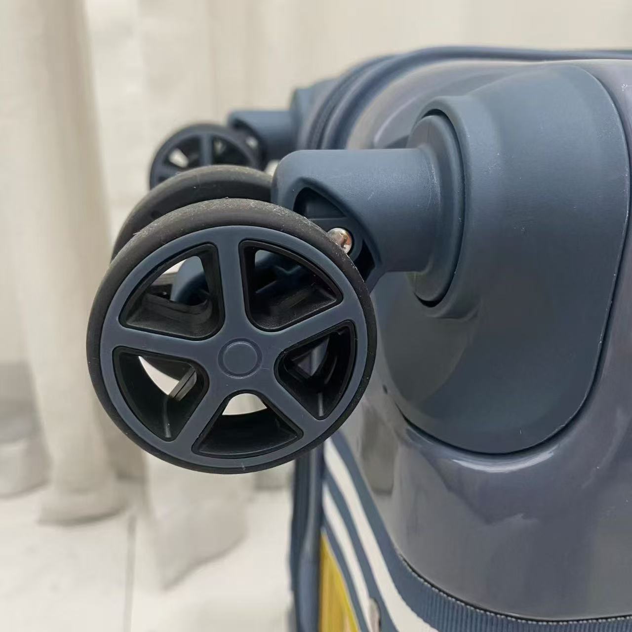 Close-up detail of double 360-degree spinner wheel on trolley suitcase