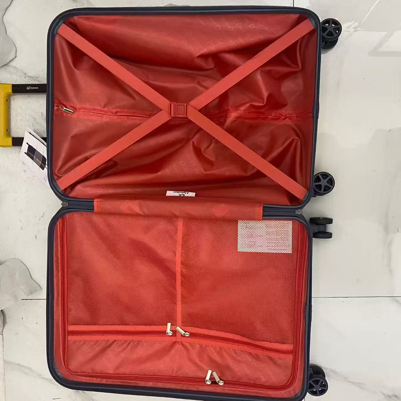Open hard-shell suitcase showing interior lining and cross straps
