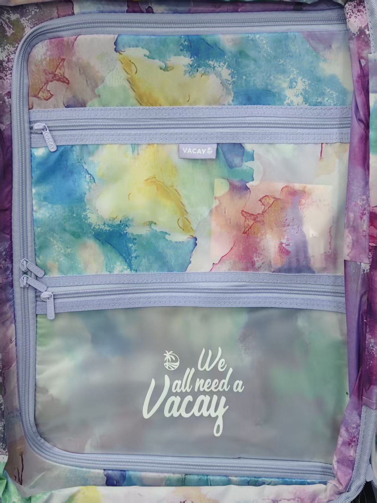 Front view of rainbow patterned hard-shell spinner luggage