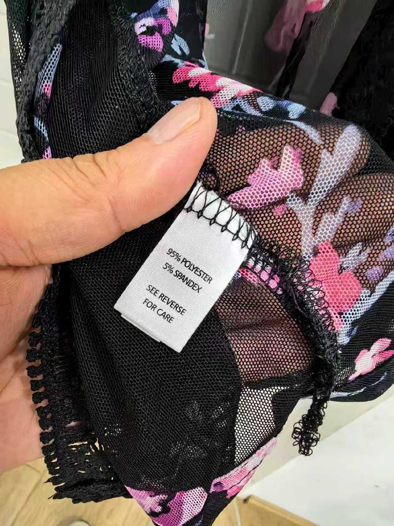 Close-up detail of black floral kimono fabric and clothing label