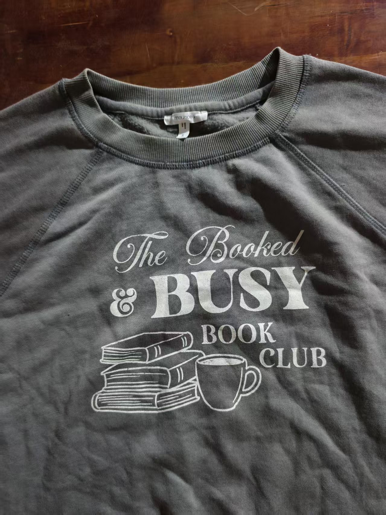 Close-up view of grey ladies' t-shirt featuring BUSY text print
