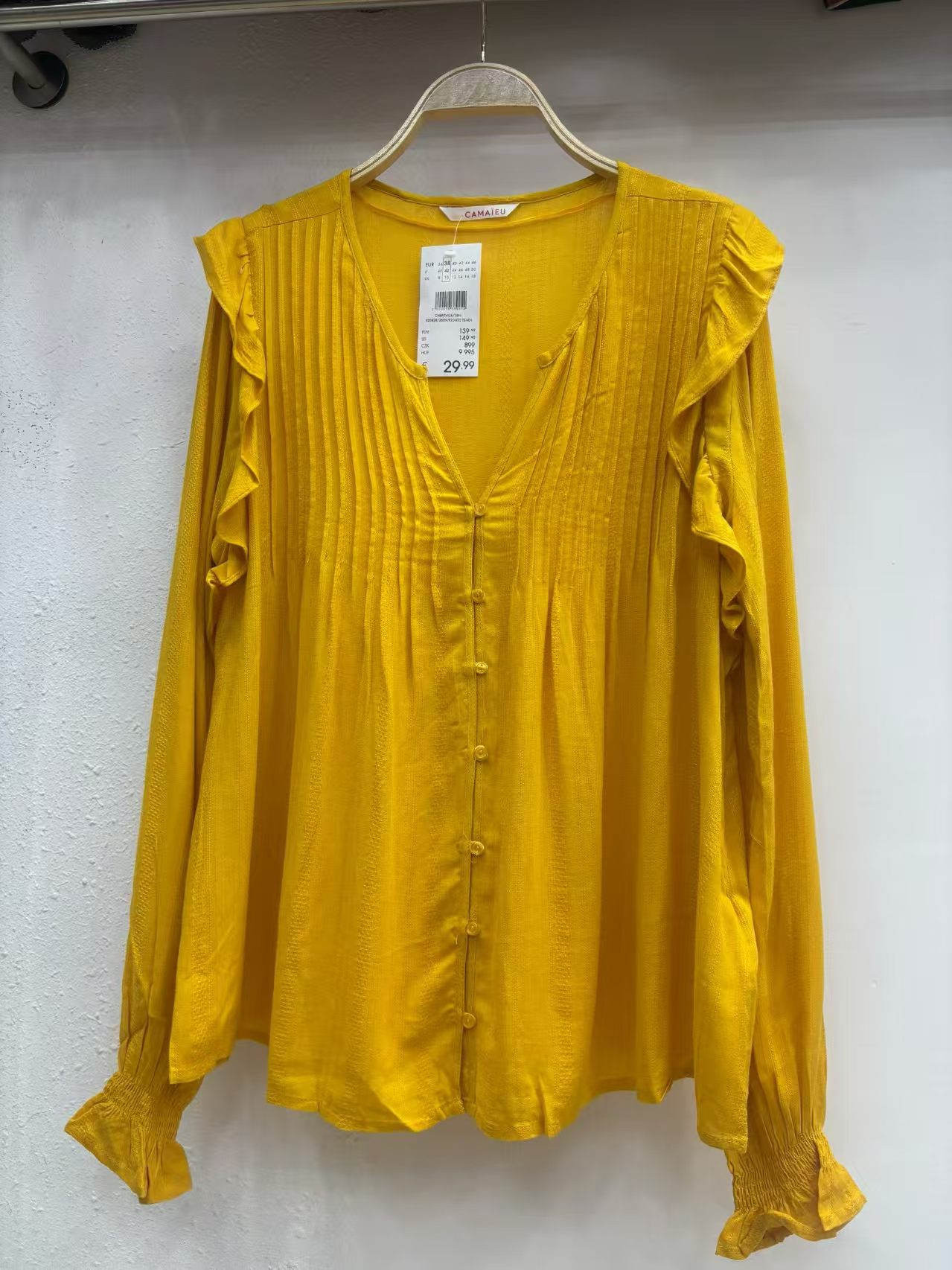 Mustard yellow ladies' long sleeve blouse displayed on a mannequin