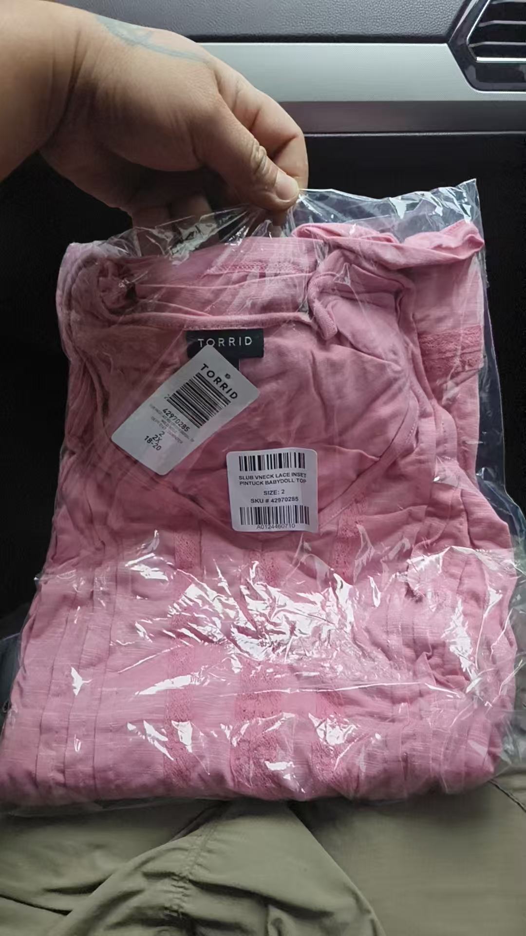 Pink ladies' long sleeve v-neck blouse folded with brand label visible