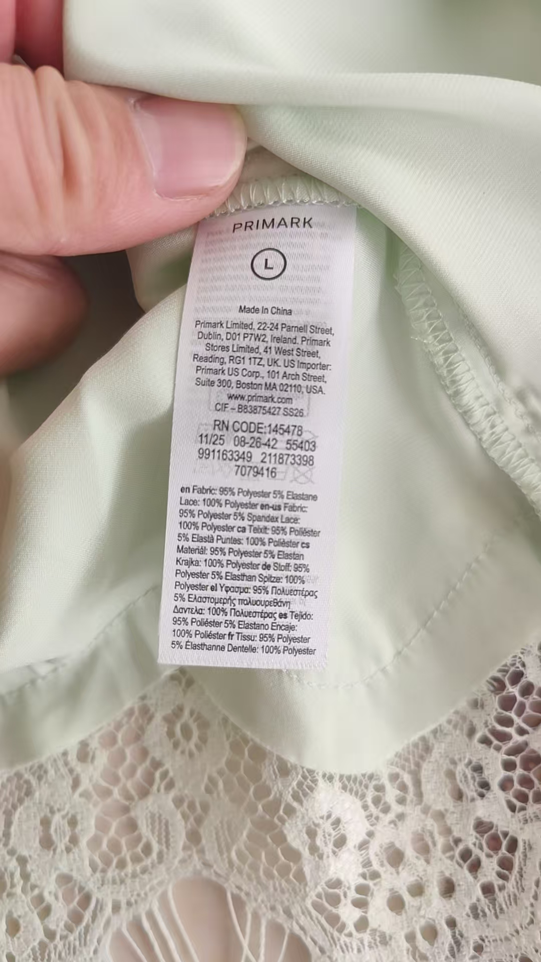 Close-up view of light green blouse fabric and neck label detail