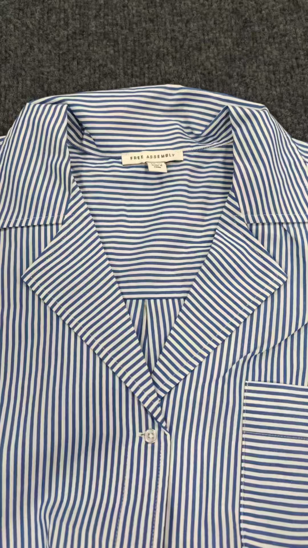 Light blue striped ladies' blouse displayed flat showing V-neckline