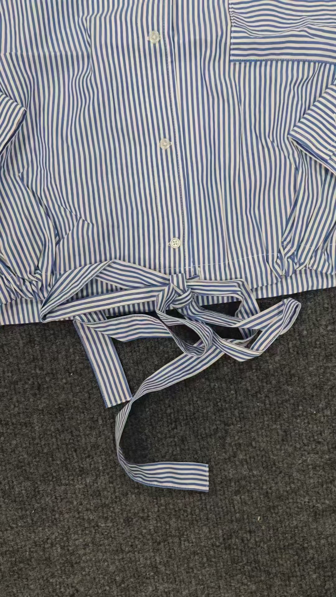 Side tie detail of light blue striped ladies' blouse