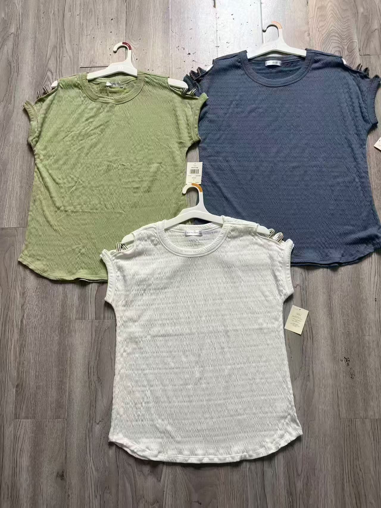 White ladies' short sleeve blouse displayed on a clothing rack