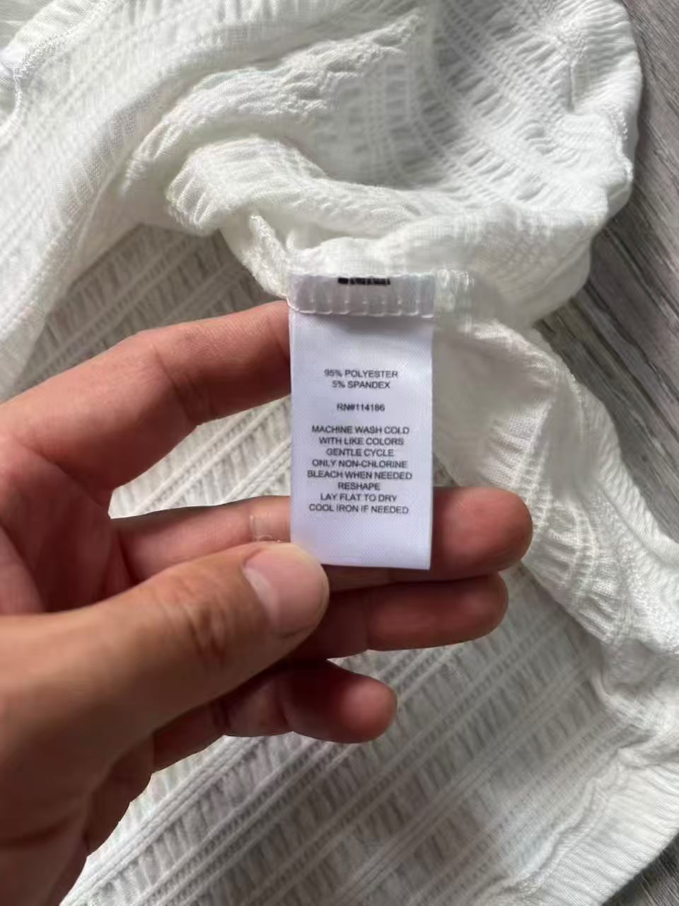 Close-up detail of ladies' blouse brand label and care tag