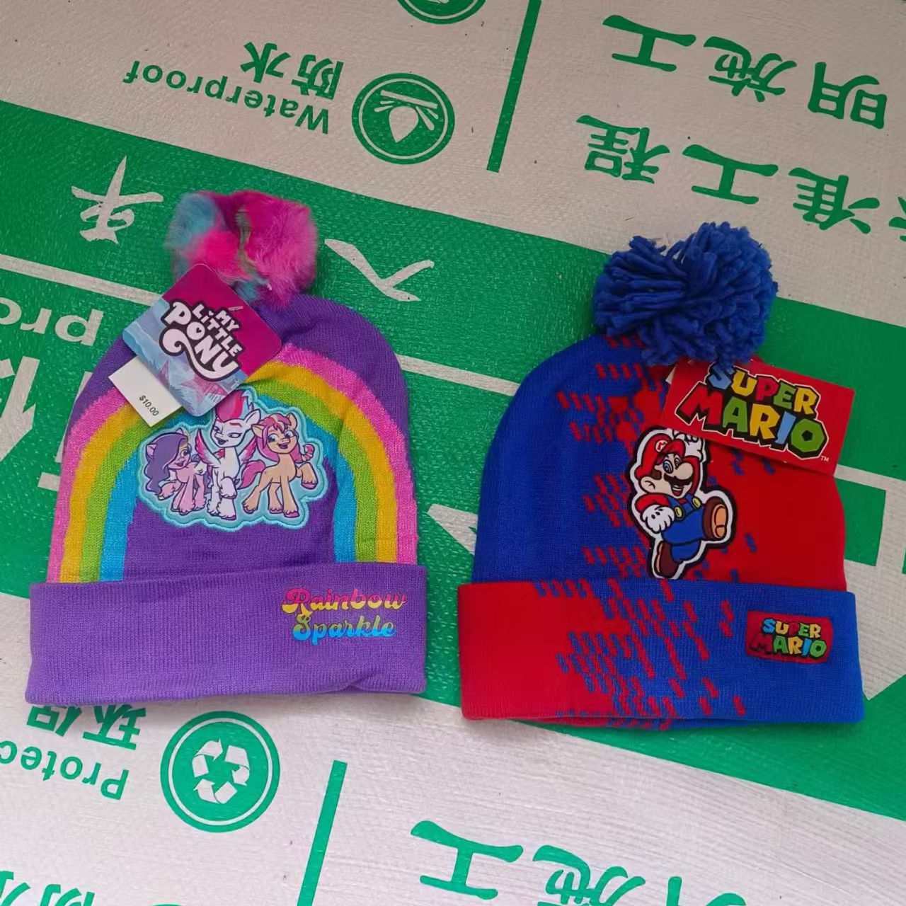 Kids' character knit beanies featuring Super Mario and My Little Pony patterns stacked together