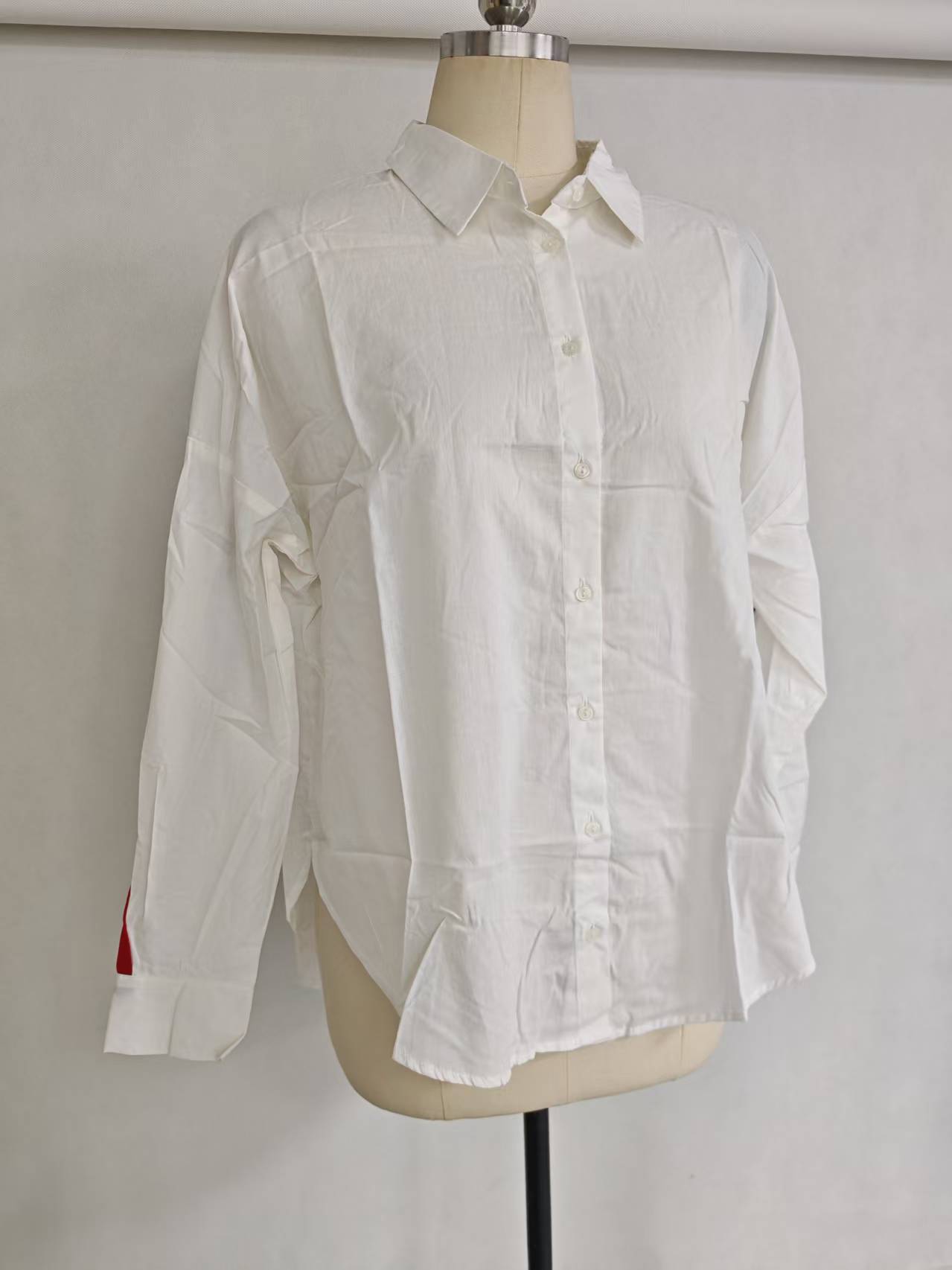 White 100% cotton ladies' long sleeve shirt displayed flat