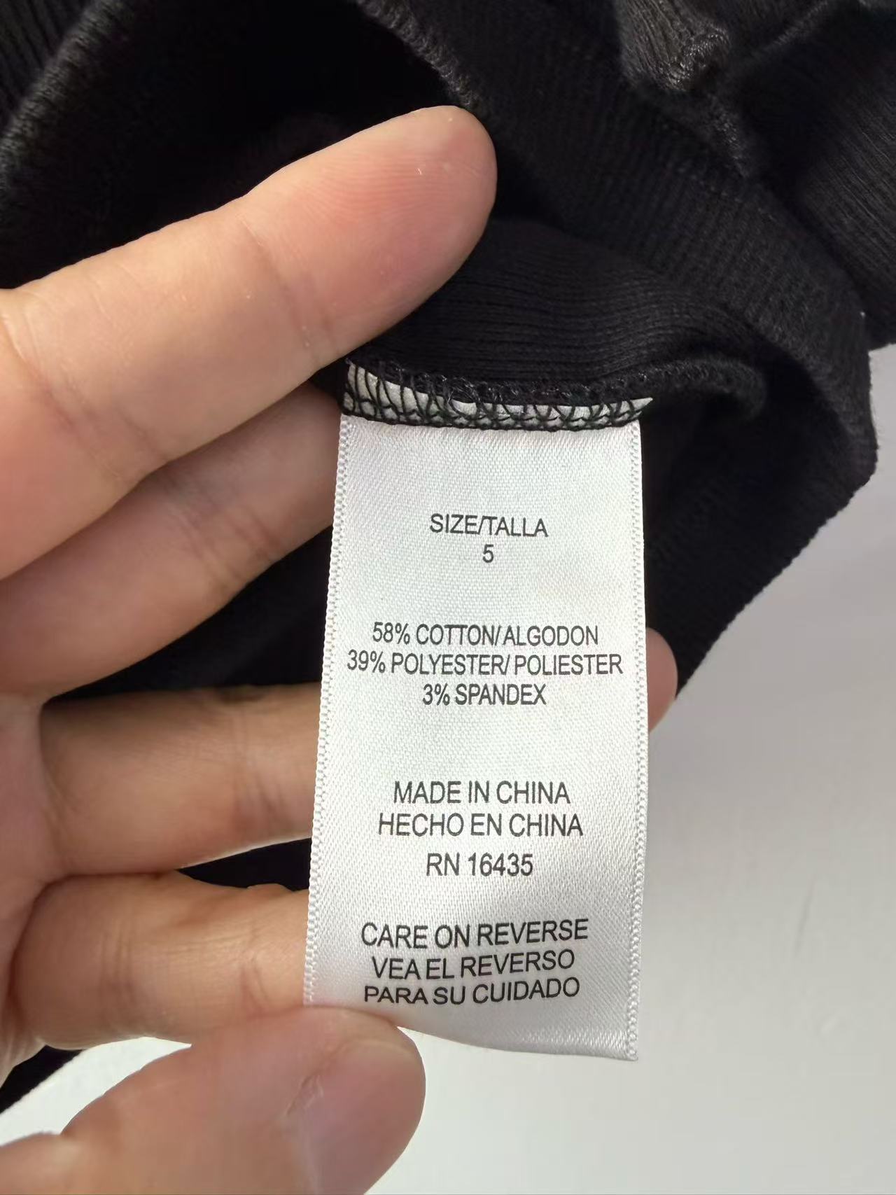 Close-up detail of girl's t-shirt clothing brand label and neck seam