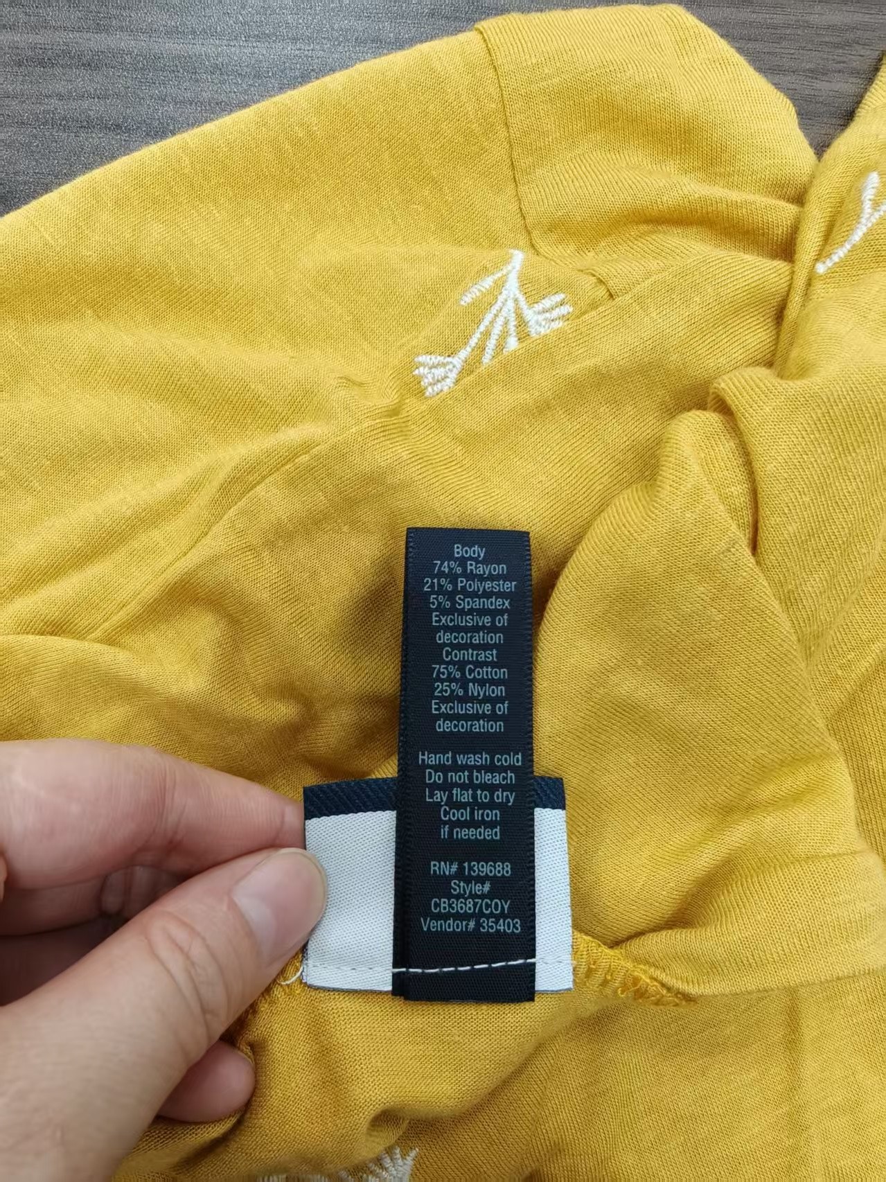 Mustard yellow ladies' short sleeve t-shirt displayed on a mannequin with water bottle