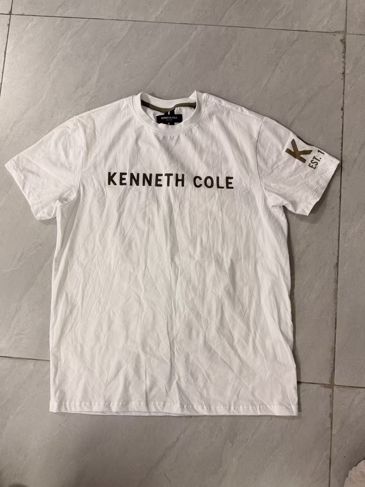 White men's short sleeve cotton t-shirt with Kenneth Cole graphic print displayed flat