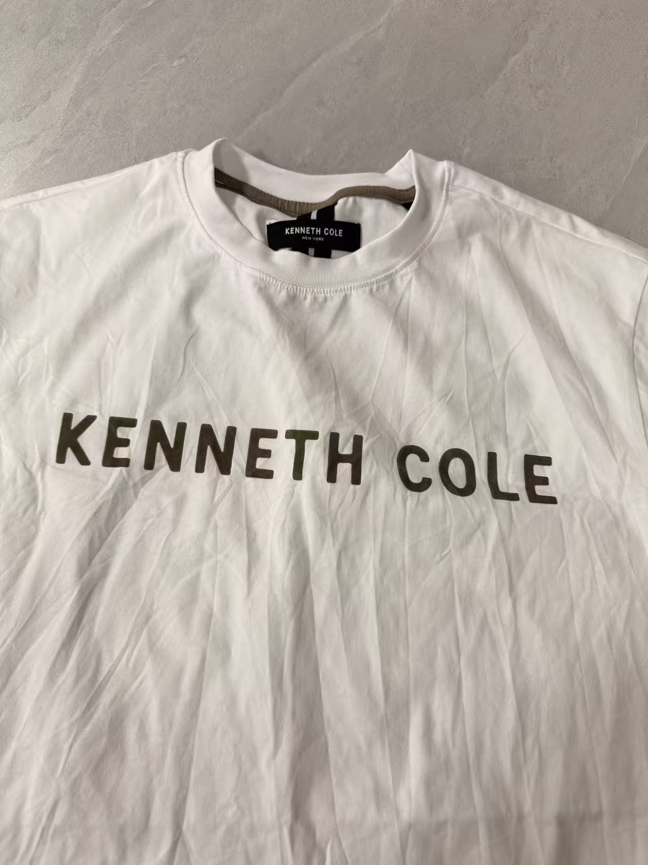 Close-up detail of Kenneth Cole graphic print on white men's short sleeve t-shirt