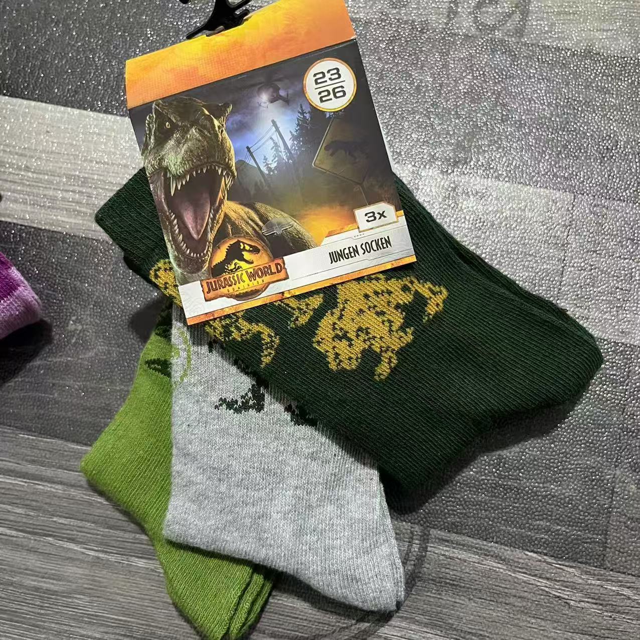 Dark green and light green kids' cotton socks displayed flat with packaging card