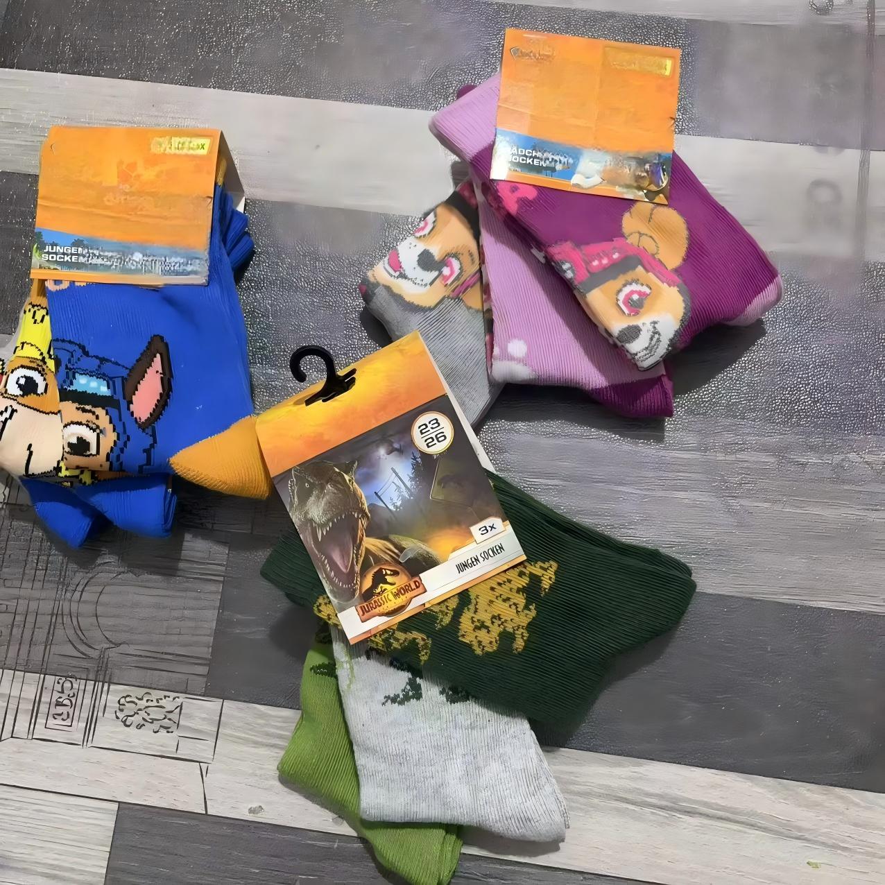 Multiple pairs of kids' colorful cotton socks stacked together on hangers with packaging tags