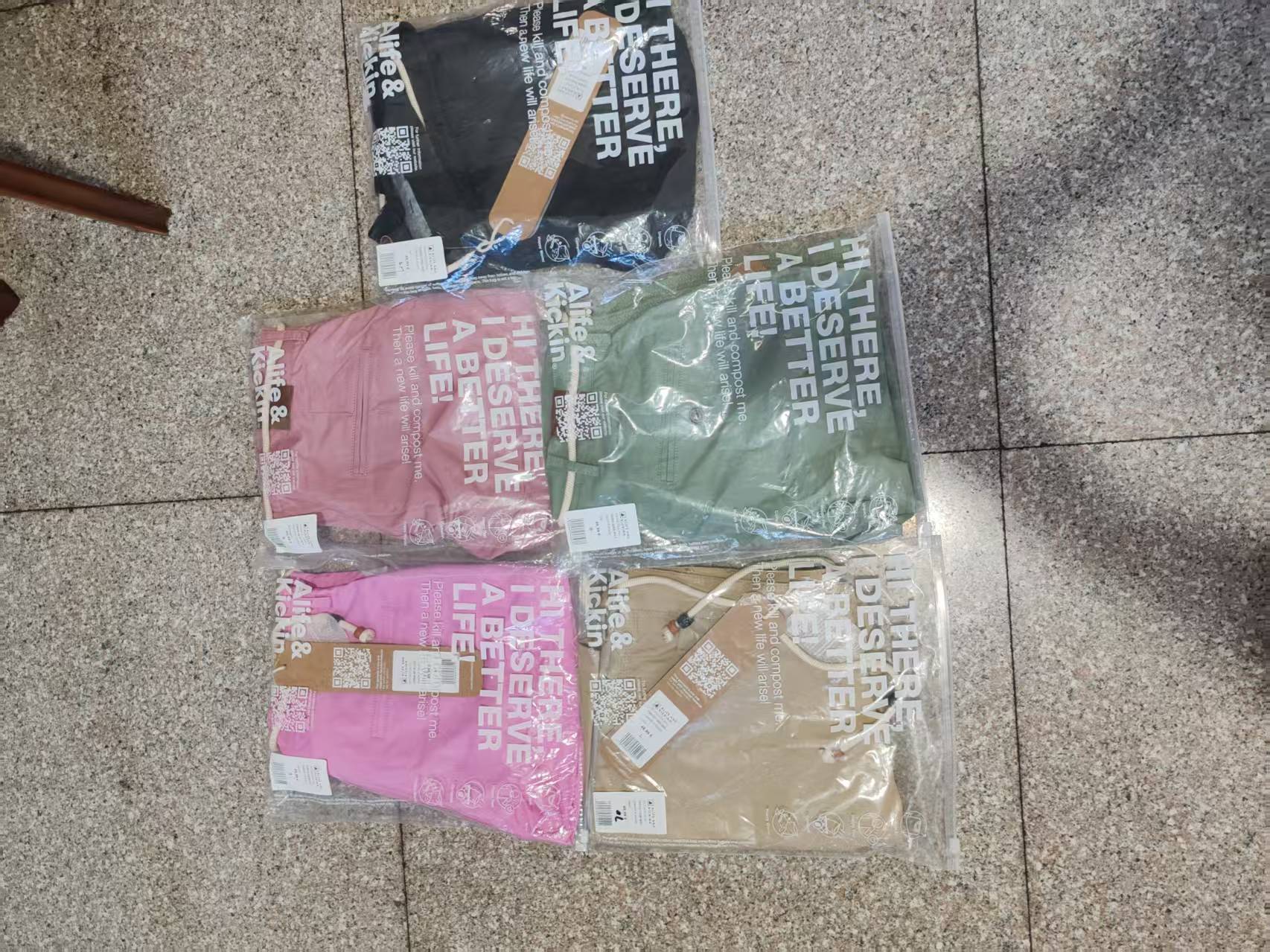 Multiple colors of women's casual shorts packaged and displayed in retail background setting.