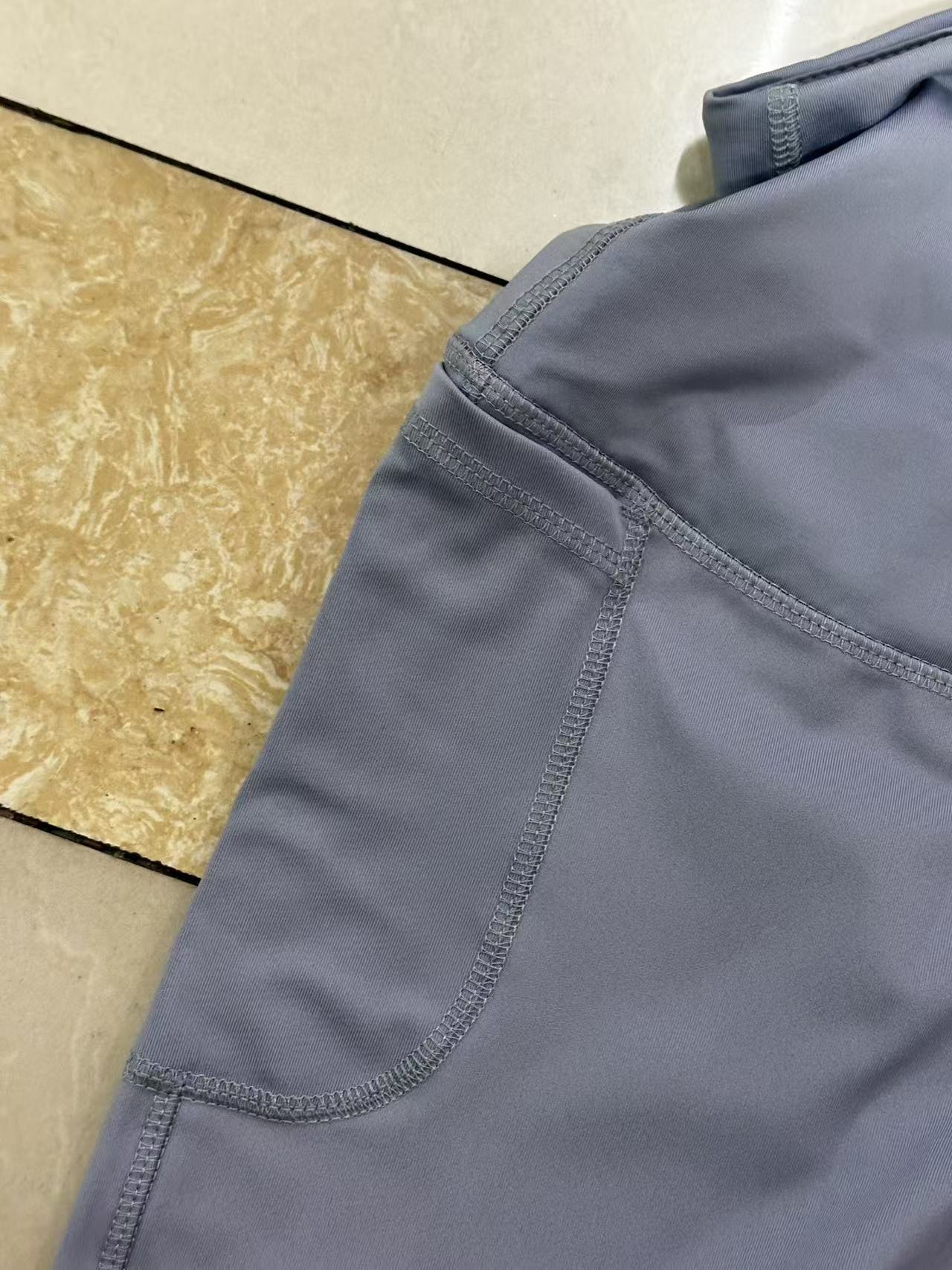 Side-angle detail shot of green women's athletic shorts showcasing fabric texture and hem cut.
