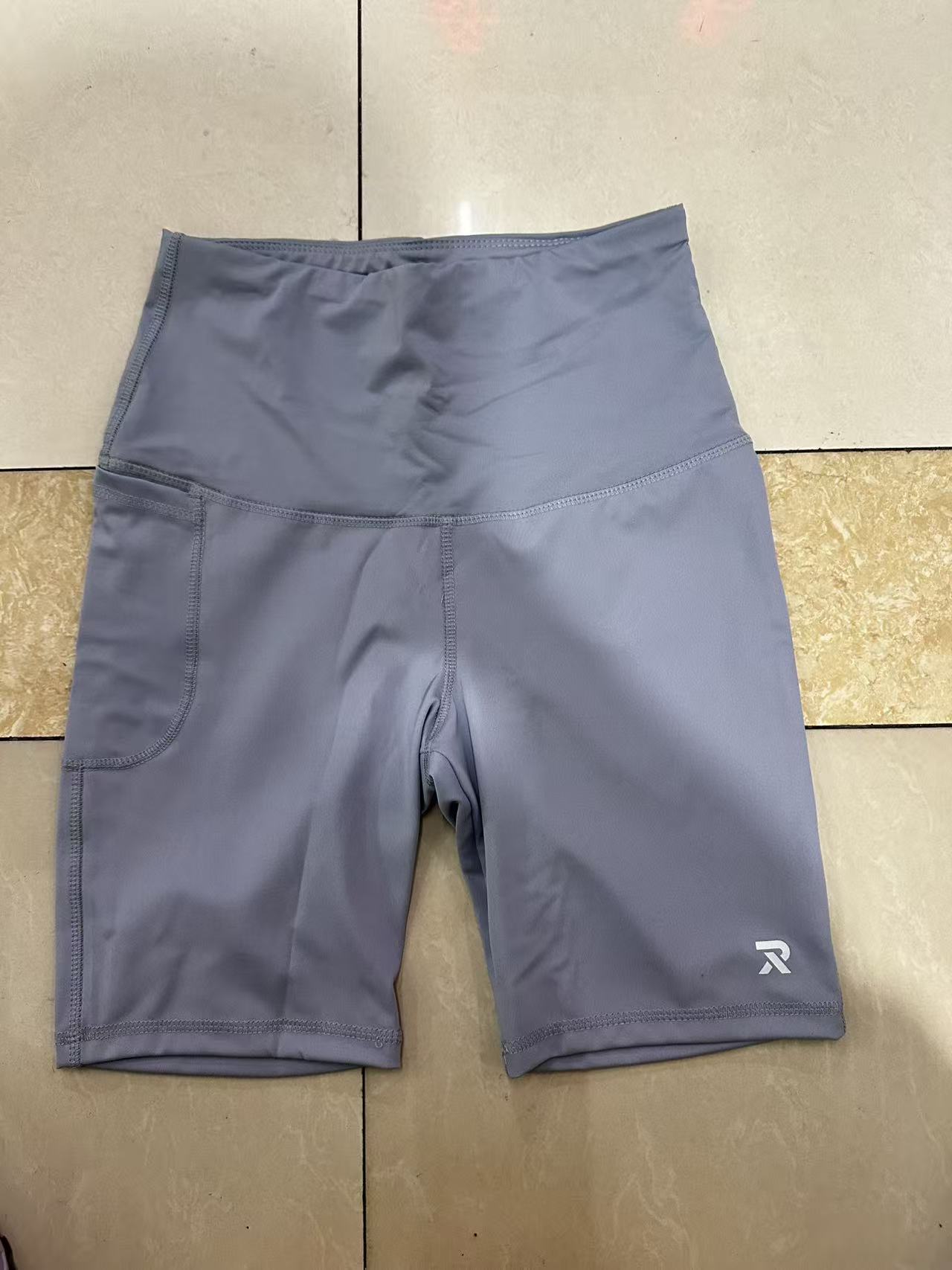 Light blue women's athletic shorts with white inner lining, laid flat on floor.