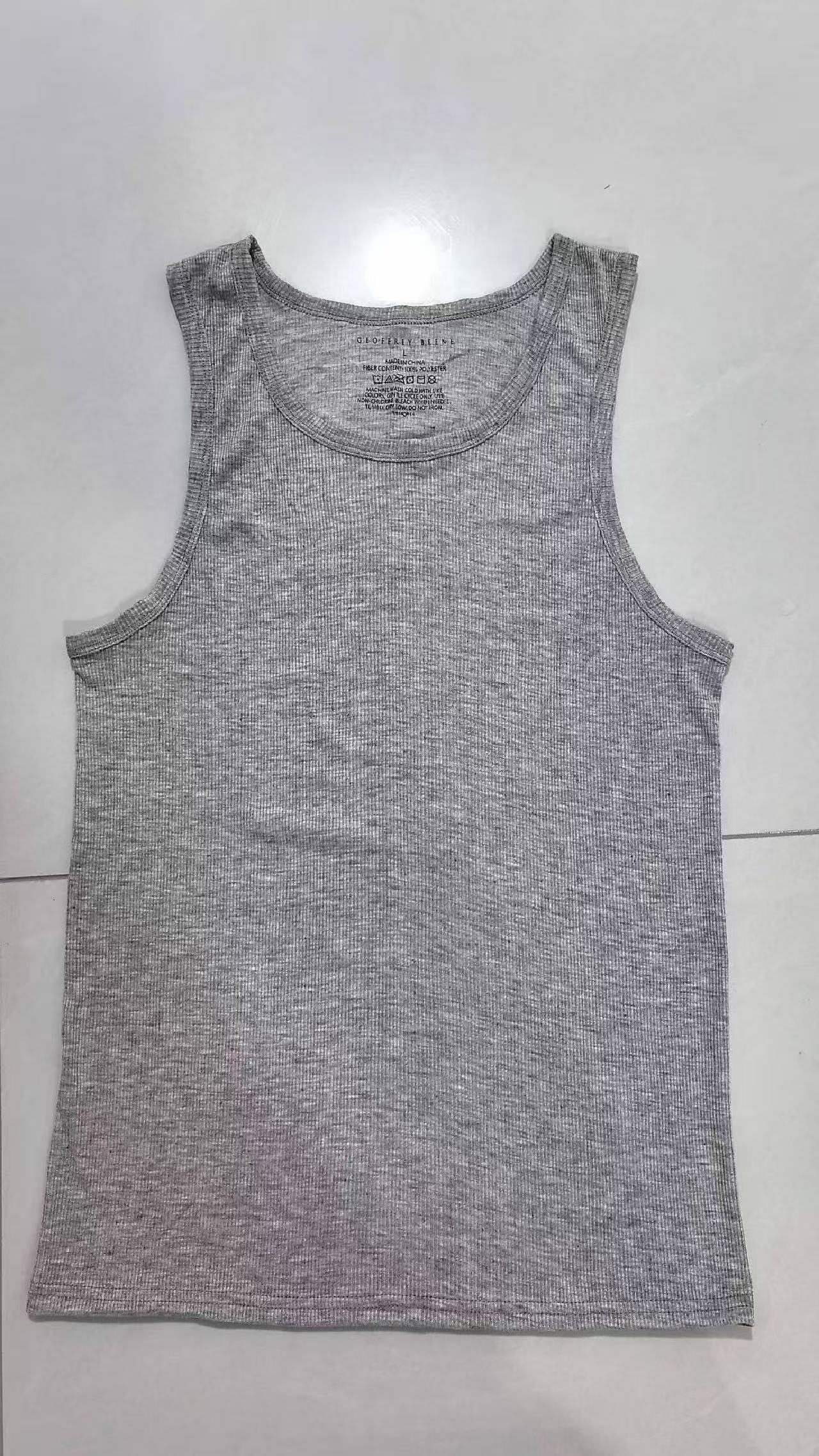 Men's sleeveless tank tops in white, grey, and black stacked and laid flat.