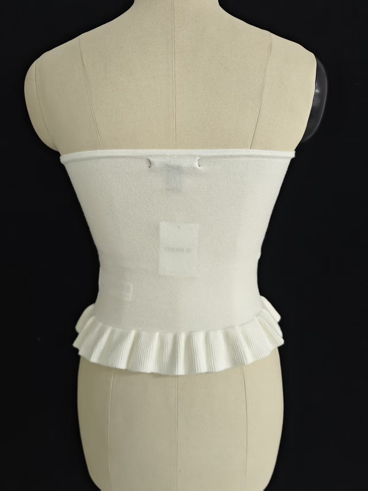 Back view of white women's strapless tube top displayed on a torso mannequin.