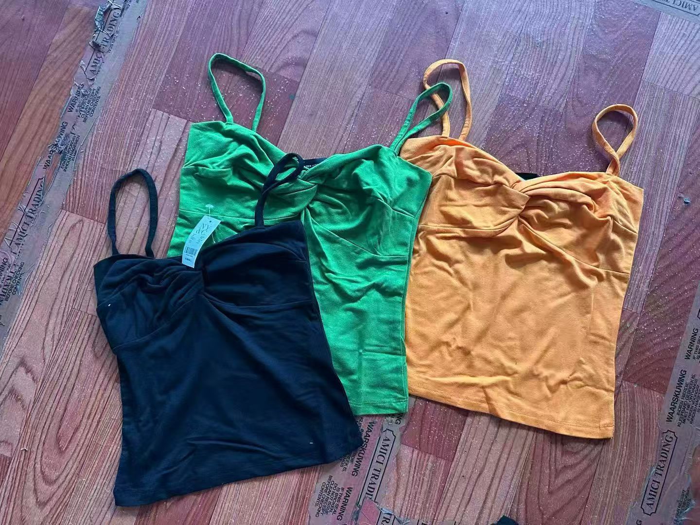 Women's ribbed camisole tank top in orange, green, and black displayed together.
